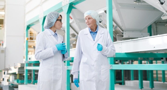 Workers in a food manufacturing facility wearing protective gear, receiving training on proper food safety and hygiene practices U-Train Mérieux NutriSciences (MxNS)